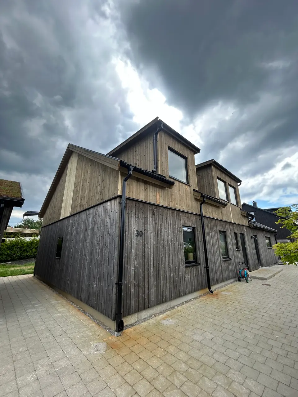 Nybyggd modern villa med mörk träpanel — totalentreprenad av KAAB Bygg