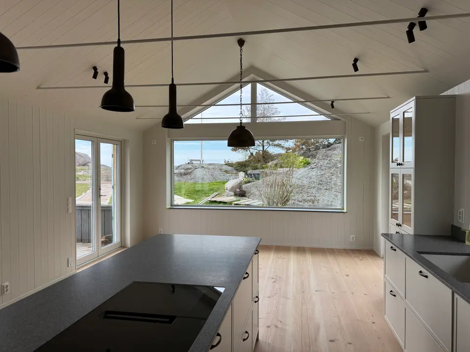 Ljust kustkök med panoramafönster mot havet — KAAB Bygg