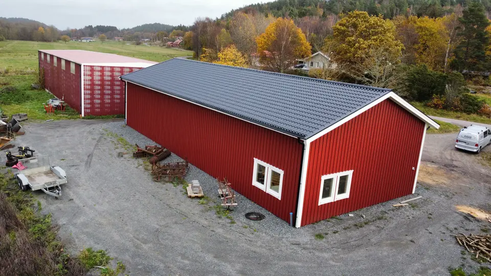 Nyuppförd verksamhetsbyggnad med svart plåttak sedd från ovan — KAAB Bygg