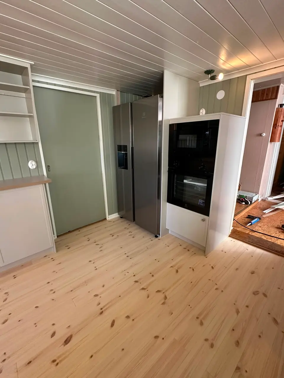Grågröna högskåp med inbyggd ugn och öppna skåpfack